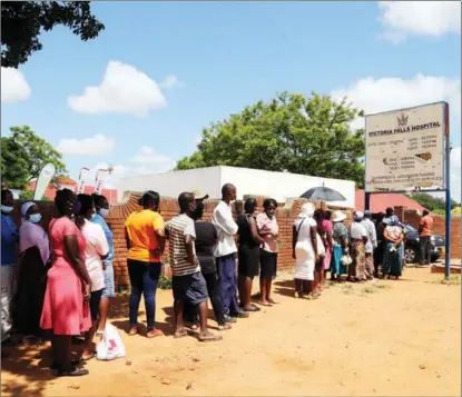  ?? CHEN YAQIN / XINHUA ?? Zimbabwean­s wait to get a dose of the Sinopharm COVID-19 vaccine in Victoria Falls on March 24. China has provided vaccines to more than 50 African countries.
