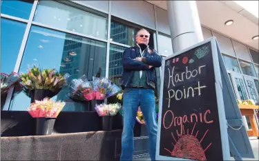  ?? Christian Abraham / Hearst Connecticu­t Media ?? Mark Hill, owner of Harbor Point Organics, in front of the new market in Stamford on Saturday. Owner Mark Hill's new specialty store and a handful of other small markets nearby are left to service a diverse and growing community without players like Stop & Shop, ShopRite, or Trader Joe’s.