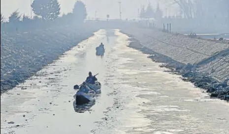  ?? PTII ?? Boatmen row their boats on a partially frozen stream on the outskirts of Srinagar on Thursday.