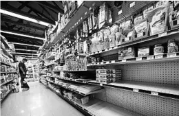  ?? ROBERT F. BUKATY/AP ?? Shelves once stocked with canning supplies sit empty at a South Portland, Maine, store.
