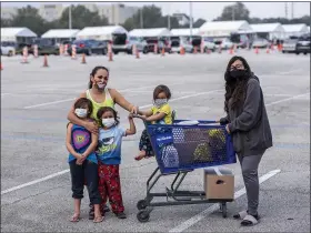  ?? SCOTT DALTON — THE WASHINGTON POST ?? Adriana Contreras and her four children, Delilah, 17, Diana, 8, Dominic, 5, Damian, 3, got food at the pedestrian section of a distributi­on center at NRG Stadium in Houston on Nov. 21.