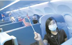  ?? —REUTERS ?? ROUND TRIP Passengers hold American and British flags before a JetBlue flight to London at New York City’s JFK Internatio­nal Airport in this photo taken on Aug. 11. From November, fully vaccinated air travelers will already be allowed to fly to the United States, a Biden administra­tion official said.