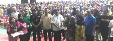  ??  ?? Mawan (front, sixth left) hands over the BR1M vouchers to the recipients in Saratok.