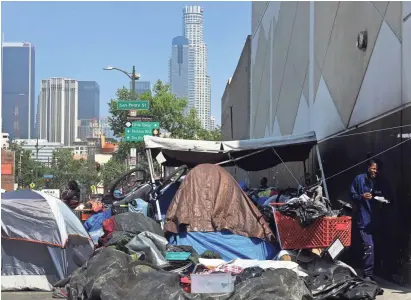  ?? FREDERIC J. BROWN/AFP/GETTY IMAGES ?? Homeless encampment­s crowd a downtown Los Angeles sidewalk on Skid Row.