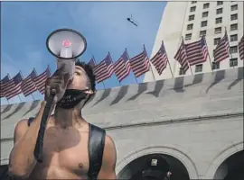  ?? Robert Gauthier Los Angeles Times ?? MARCUS OWEN uses a bullhorn to lead a large rally at City Hall for George Floyd, who died following his arrest by Minneapoli­s police officers on May 25.