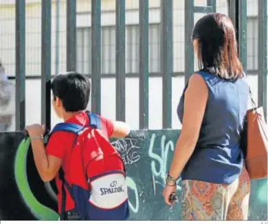  ?? D. S. ?? Una madre con su hijo en la puerta de un colegio público.