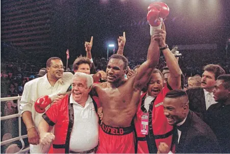  ??  ?? Lou Duva ( front left) celebrates with Evander Holyfield after Holyfield’s knockout of James “Buster” Douglas on Oct. 25, 1990. | DOUGLAS C. PIZAC/ AP