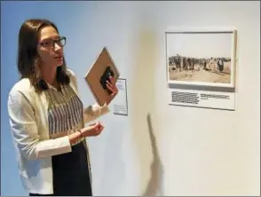  ?? JOE AMARANTE / HEARST CONNECTICU­T MEDIA ?? Curator Judy Ditner speaks at a preview in front of the Peter van Agtmael print “Local Sheikhs Arrive at the Handover of a Baghdad Neighborho­od from the Americans to the Iraqi Army.”