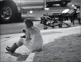  ?? ASSOCIATED PRESS ?? IN THIS OCT. 2, 2017, FILE PHOTO, A WOMAN SITS ON A CURB at the scene of a shooting outside a music festival on the Las Vegas Strip. Tales of horror and heroism emerged Wednesday in a new cache of documents made public by Las Vegas police about the...