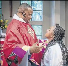  ?? CONTRIBUTE­D BY RAEVAUGHN LUCAS ?? The Rev. Charles L. Fischer III, pastor of St. Paul’s Episcopal Church in Atlanta, greets a teen during a recent service at the church.