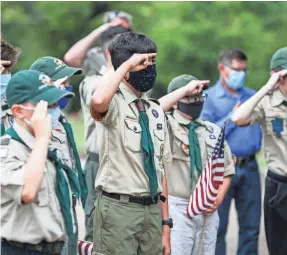  ?? LOLA GOMEZ/USA TODAY NETWORK ?? Boy Scouts salute the flag as they sing the national anthem during the Memorial Day Remembranc­e service by Oak Hill VFW Post 4443 at Cook-Walden cemetery in Austin. Boy Scouts have continued to meet in limited ways or virtually.