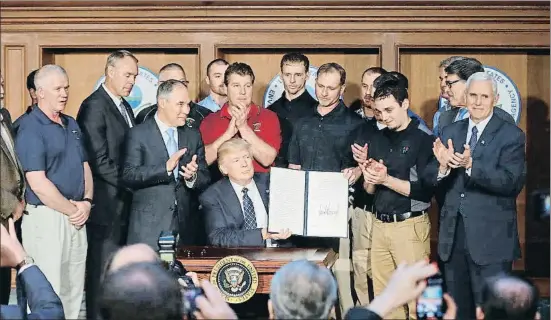  ?? PABLO MARTINEZ MONSIVAIS / AP ?? Donald Trump, jaleado en el momento de enseñar su firma en el decreto que desmantela el legado medioambie­ntal de Obama