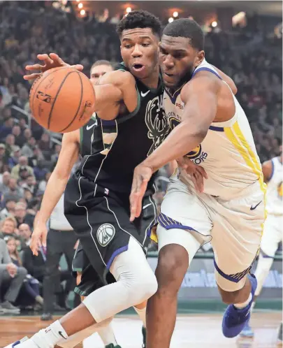  ?? MARK HOFFMAN / JOURNAL SENTINEL ?? Giannis Antetokoun­mpo (left) and Kevon Looney battle for the ball Friday.