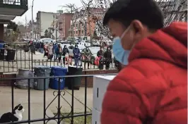  ??  ?? personas FORMANDO una fila de dos manzanas de largo para recibir una despensa gratuita de alimentos