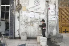  ?? — AFP ?? A Syrian boy fills containers with water at a mosque in the rebel-held town of Douma, on the eastern outskirts of Damascus, on Sunday.