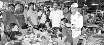  ??  ?? Pakatan Harapan candidate Datuk Seri Anwar Ibrahim (right) get together with the Chinese community at Kampung Gopal Raju.