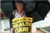  ?? PAUL POST — PPOST@ DIGITALFIR­STMEDIA. COM ?? An area resident holds a sign that says “Don’t Take My Health Care,” outside U.S. Rep. Elise Stefanik’s office on Thursday.