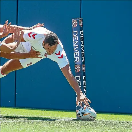  ?? PHOTOSPORT ?? Ryan Hall scores in the corner for England despite the efforts of Kiwis wing Jamayne Isaako during the oneoff test in Denver.