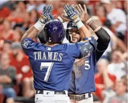  ?? ASSOCIATED PRESS ?? The Brewers’ Eric Thames celebrates with Jonathan Villar after hitting a two-run home run off Cincinnati Reds relief pitcher Wandy Peralta during the sixth inning.