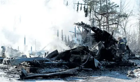  ?? LAURA BARTON/ WELLAND TRIBUNE ?? A member of the Wainfleet’s fire department walks carefully through the remainders of a home at 11473 Moore Rd. N. in Wainfleet. The home burned down in the early morning hours on Thursday. The wreckage was still smoulderin­g just before noon and was...