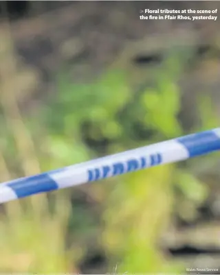  ?? Wales News Service ?? > Floral tributes at the scene of the fire in Ffair Rhos, yesterday