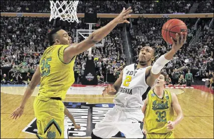  ?? BILL WIPPERT / ASSOCIATED PRESS ?? West Virginia guard Jevon Carter drives against Notre Dame’s Bonzie Colson. Carter scored 24 points, matching a season high, as the Mountainee­rs advanced to the Sweet 16.