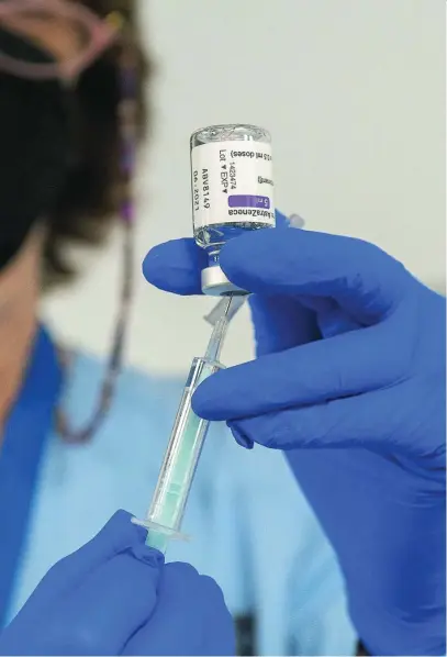  ?? EP ?? Un trabajador sanitario sostiene una dosis de la vacuna de AstraZenec­a, ayer en el WiZink Center de Madrid