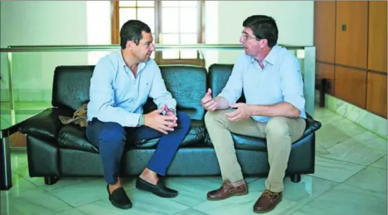  ?? / PACO PUENTES ?? Juan Manuel Moreno (izquierda) y Juan Marín conversan en una sala del Parlamento andaluz, en 2016.