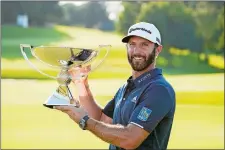  ?? JOHN BAZEMORE/AP PHOTO ?? Dustin Johnson celebrates with the FedEx Cup trophy after winning the Tour Championsh­ip on Monday at East Lake Golf Club in Atlanta.