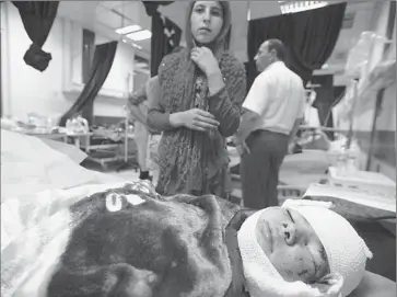  ?? Safin Hamed
AFP/Getty Images ?? AN IRAQI child is treated at a hospital in the northern city of Dohuk after a bombing at her school in Qabak village that killed 12 children and the principal. A bombing at a nearby police station killed two officers.