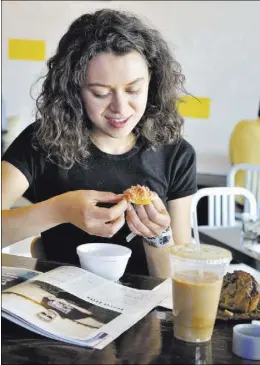  ??  ?? Lizeth Sarabia peels a fig during breakfast at Makers and Finders Coffee, a popular place for people who work and live downtown.