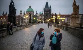  ?? Photograph: Martin Divíšek/EPA ?? Women walk on Charles Bridge in Prague. The Czech Republic has struggled to contain an infection rate that rose to 15,000 new cases a day at the beginning of November, making it the worst-hit country in Europe on a per-capita basis.