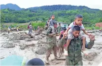  ?? COLOMBIAN ARMY/EPA ?? Colombian soldiers help victims leave the area of the mudslides Sunday. The death toll has passed 200, but scores are still missing. Rescuers intensifie­d their efforts, hoping to find survivors a day after heavy rains sent an avalanche of mud and...