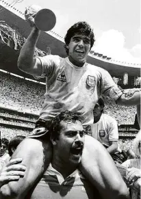  ?? Gary Hershorn - 29.jun.86/Reuters ?? Maradona é carregado por Roberto Cejas com a taça da Copa do Mundo, em 1986