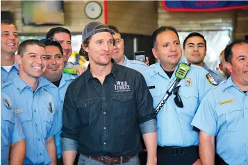  ?? John Mone/Associated Press ?? ■ Actor Matthew McConaughe­y poses with first responders Sunday in Houston as he surprises them with catered lunches. McConaughe­y said he wanted to celebrate National First Responders Day by giving thanks to the responders who risked their lives during Hurricane Harvey.