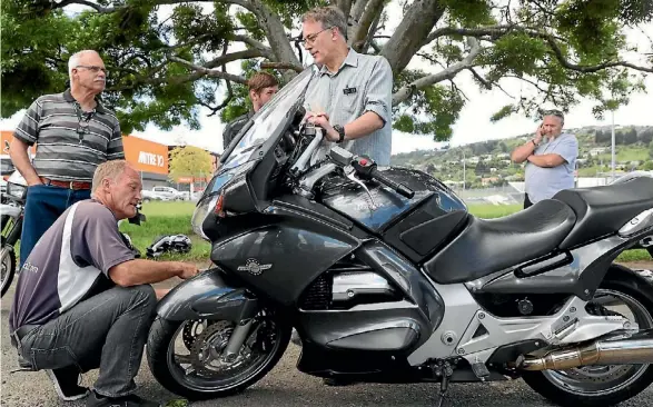  ?? PHOTO: MARION VAN DIJK/ FAIRFAX NZ ?? Dave Moss, left, works on Hank Verhoeven’s motorcycle.