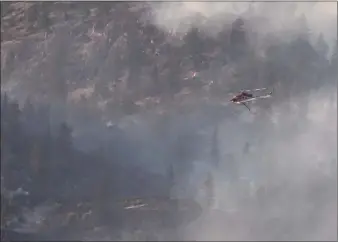  ?? MEGHANN FLETCHER/Special to The Herald ?? A helicopter is pictured against the Thomas Creek wildfire near Okanagan Falls.