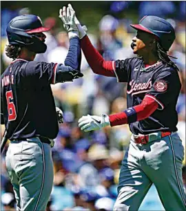  ?? PHOTOS BY RYAN SUN / AP ?? Washington’s CJ Abrams, right, celebrates with Jesse Winker after hitting a solo home run during the first inning of Wednesday’s game at Dodger Stadium.