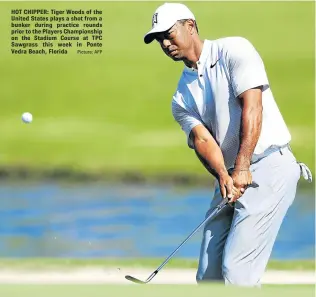  ?? Picture: AFP ?? HOT CHIPPER: Tiger Woods of the United States plays a shot from a bunker during practice rounds prior to the Players Championsh­ip on the Stadium Course at TPC Sawgrass this week in Ponte Vedra Beach, Florida