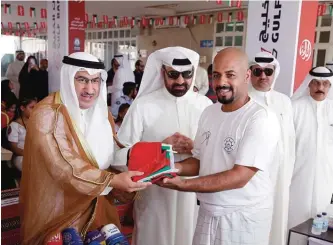  ??  ?? Dr Mohammad Abdulatif Al-Fares, Minister of Education and Minister of Higher Education hands the Kuwaiti flag to representa­tive of the Committee of the Marine Heritage.
