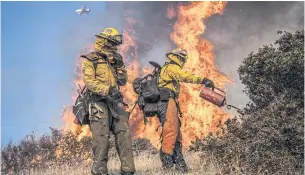 ??  ?? STRATEGIC FIGHT: Firefighte­rs with the Marin County Fire Department burn brush ahead of the Kincaid Fire in an effort to reduce fuel and increase containmen­t in California on Friday.
