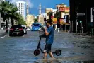  ?? Images ?? A man crosses a flooded street following heavy rains in Sharjah, United Arab Emirates, on 17 April. Photograph: Ahmed Ramazan/AFP/Getty