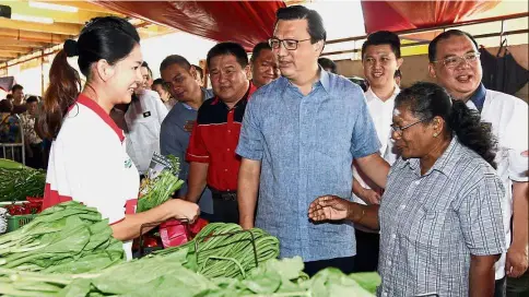  ??  ?? All smiles: Liow, Chong (behind Liow) and Siow (right) meeting with traders during a walkabout at the Seremban Wet Market.