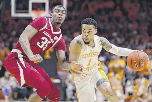  ?? Donald Page / Getty Images ?? Lamonte’ Turner, who led Tennessee with 21 points, drives past Reggie Chaney of Arkansas during their Southeaste­rn Conference matchup Tuesday at Thompson-boling Arena in Knoxville, Tennessee. Tennessee won 106-87.