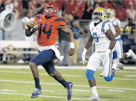  ?? Rick Scuteri Associated Press ?? KHALIL TATE has quarterbac­ked Arizona to four straight victories with an astronomic­al 1,583 yards in total offense. “That young man is dynamic and he changes the game,” UCLA coach Jim Mora said after Tate scorched Adarius Pickett and the Bruins.