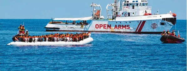  ?? Foto: Darko Bandic, afp ?? Nach diesem Muster verläuft häufig die Flucht über das Mittelmeer: Von Schleppern organisier­t, starten Migranten in Libyen in einem viel zu kleinen Schlauchbo­ot. Auf hoher See werden sie dann gerettet. Hier nimmt die Besatzung eines Schiffs der...