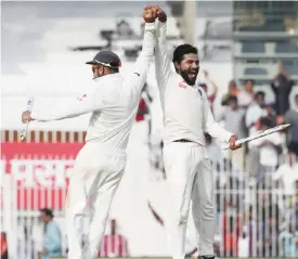 ??  ?? CHENNAI: Indian cricket captain Virat Kohli, left, and teammate Ravindra Jadeja, right, celebrates after wining the Test series against England. — AP