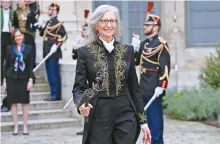  ?? AFP-Yonhap ?? U.S. photograph­er Annie Leibovitz, new member of the French Academy of Fine Arts, leaves with a sword after her induction ceremony at the Institut de France in Paris, March 20.