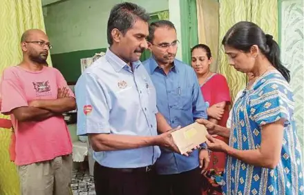  ?? BY AMIR IRSYAD OMAR
PIC ?? Social Security Organisati­on Penang director Anthony Arul Dass (second from left) handing over a cheque for RM2,000 to T. Nhaveen’s mother D. Shanti (right) at her home in George Town yesterday.