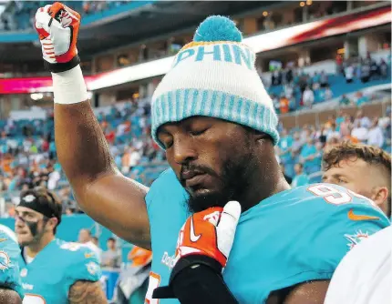  ?? WILFREDO LEE / THE ASSOCIATED PRESS ?? Miami Dolphins defensive end Robert Quinn raises his right fist during the singing of the national anthem before the team’s Aug. 9 NFL pre-season game against Tampa Bay.